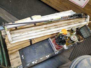 Assorted ski poles, light, brushes, fluorescent light fixture, and wooden d