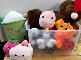 Assorted plush toys in clear bin